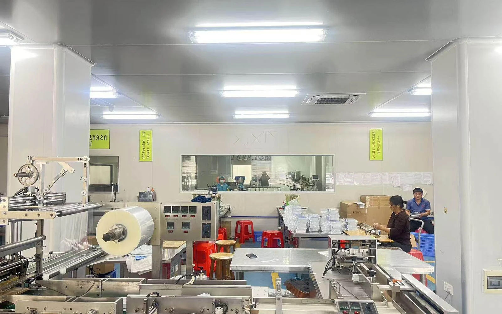 Packaging machinery and production staff in a filling room