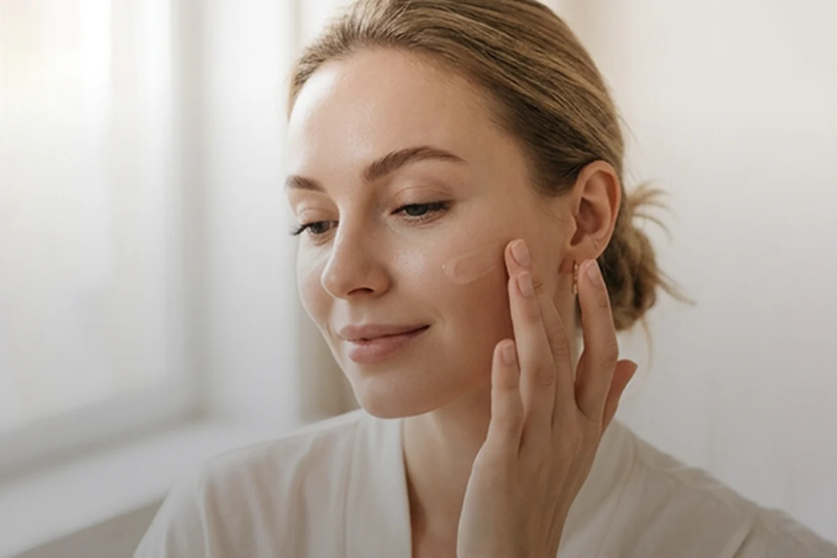 Woman applying face cream as part of a skincare routine